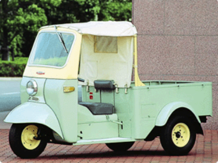 a light-yellow and green tuk tuk (also known as a auto rickshaw)